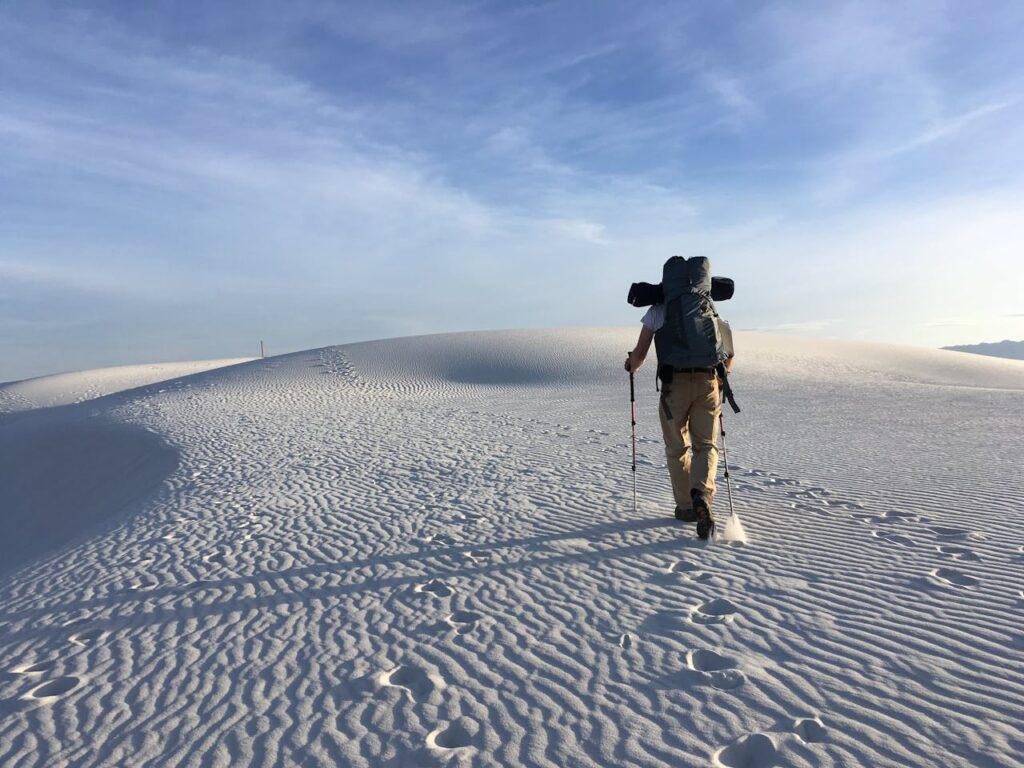 Photo of Man Holding Hiking Poles on Snow Field